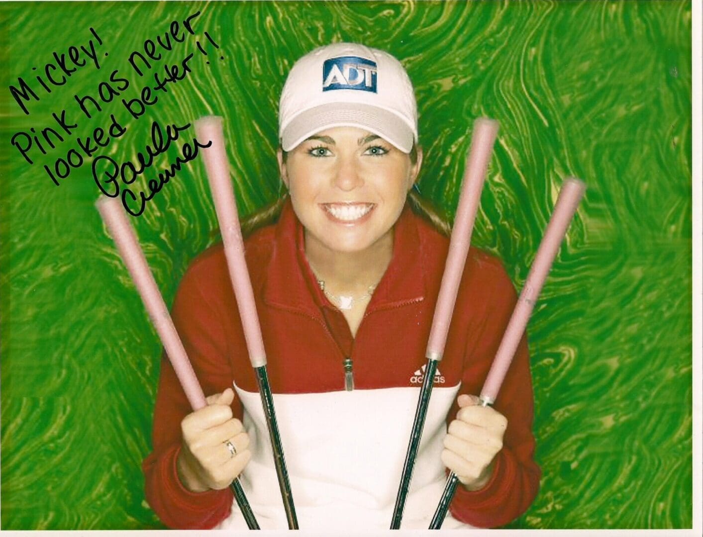 A woman holding four pink poles in her hands.