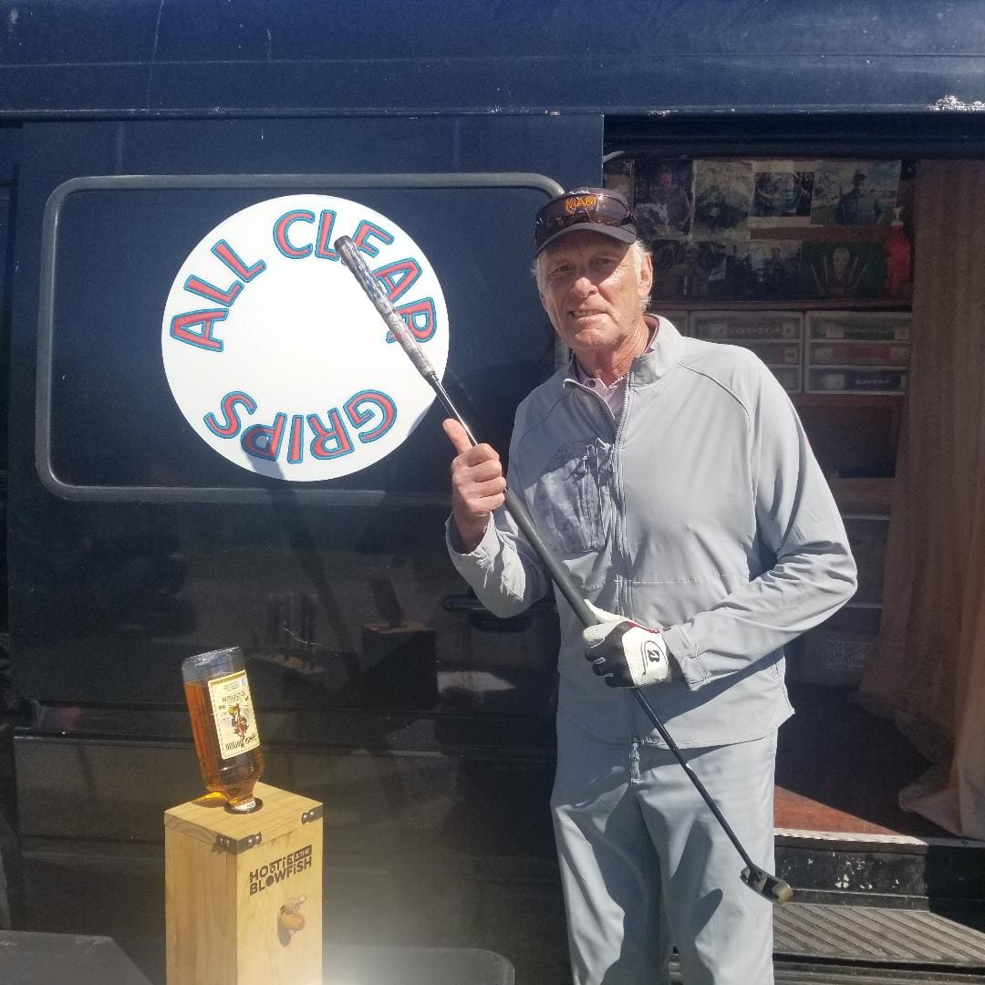 A man holding a brush in front of a sign.