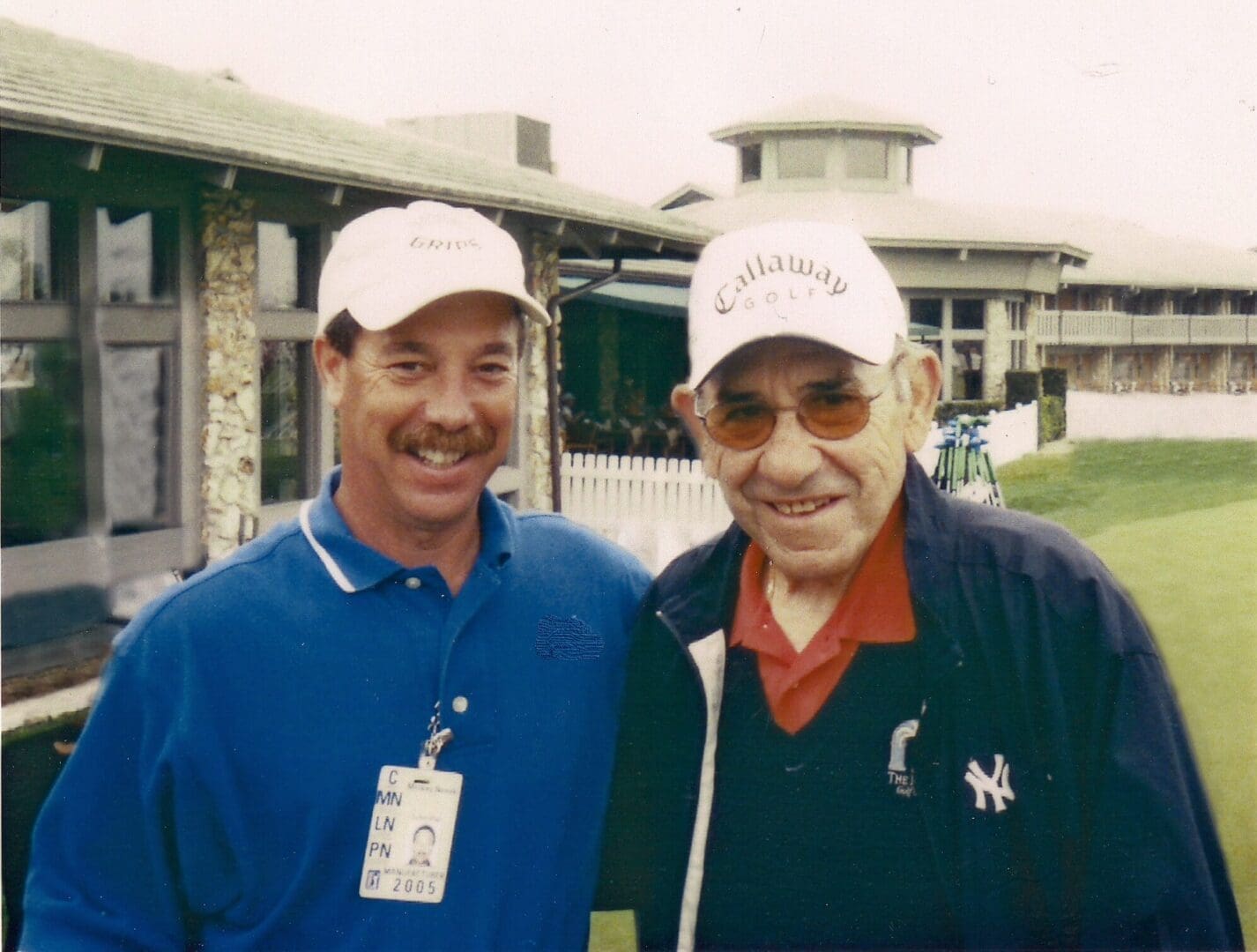 Two men standing next to each other on a golf course.