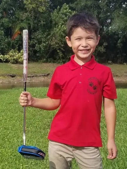 A young boy holding a baseball bat in his hand.